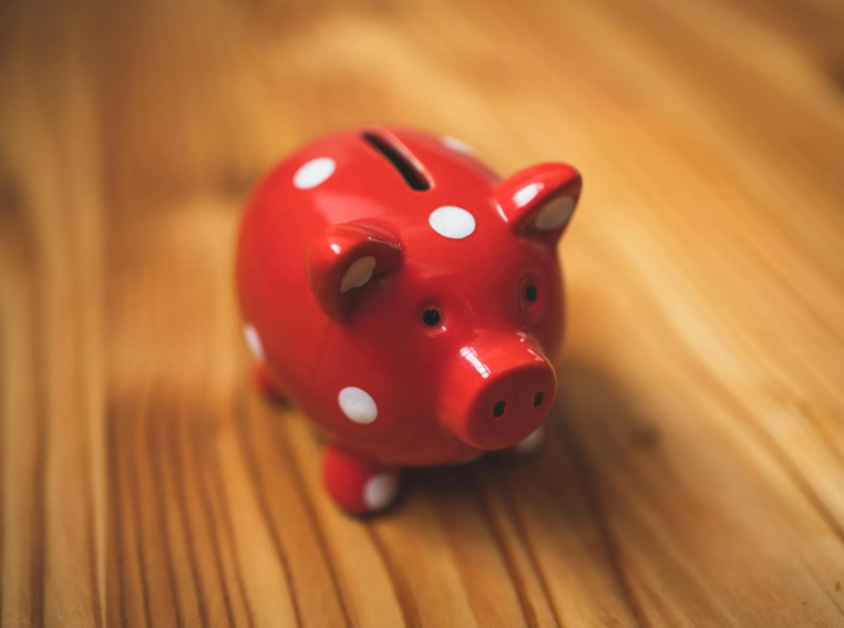 Sparegris i rød på et træbord